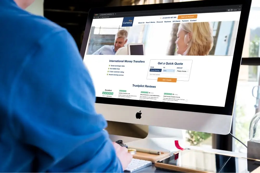 A man looking at Key Currency on an iMac